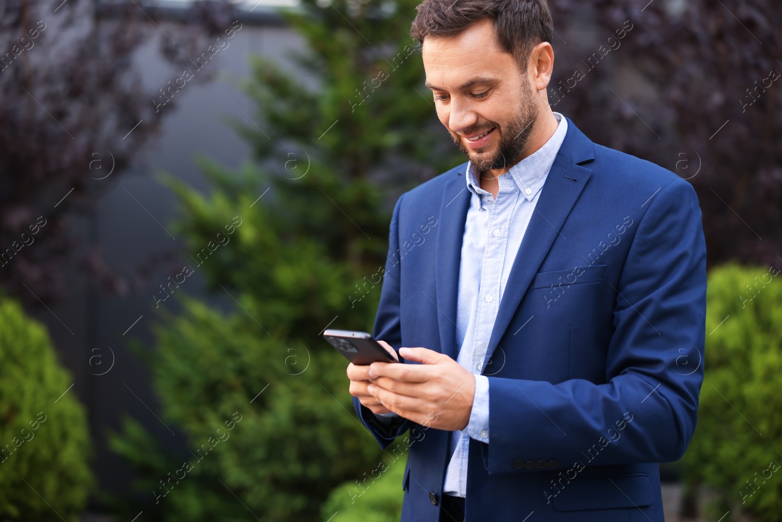 Photo of Businessman using smartphone outdoors, space for text