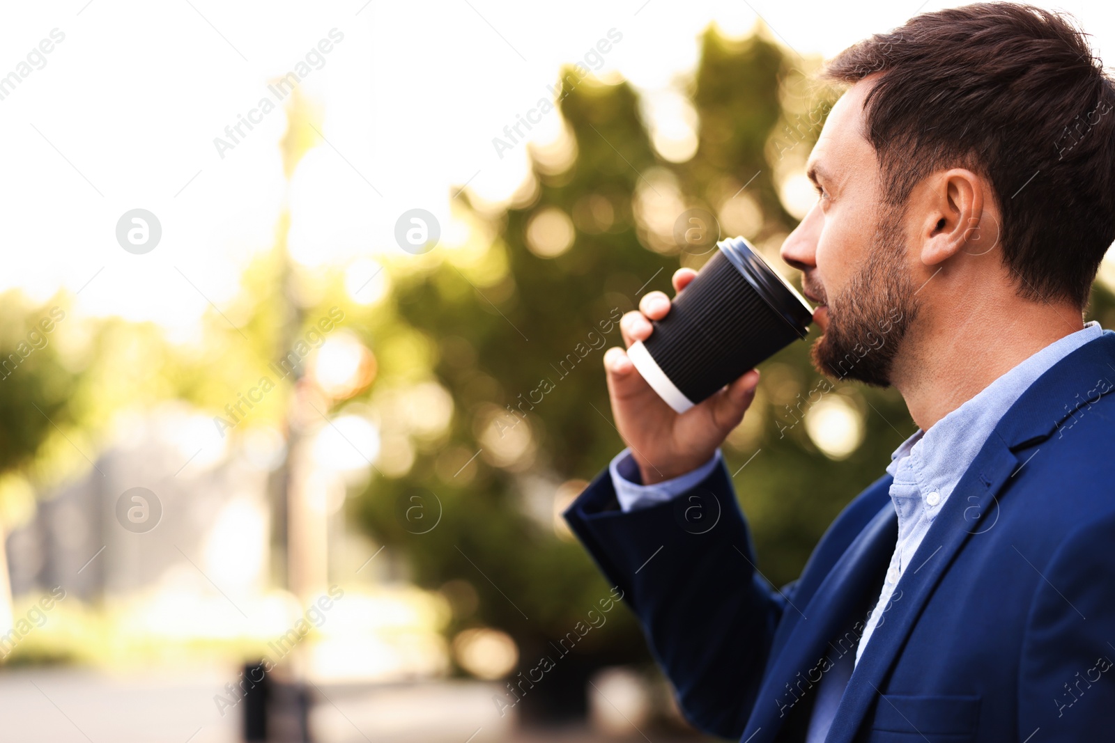 Photo of Coffee to go. Man with paper cup of drink outdoors, space for text