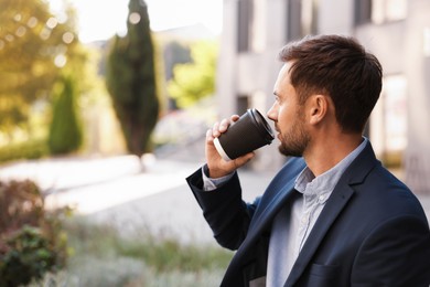 Photo of Coffee to go. Man with paper cup of drink outdoors, space for text