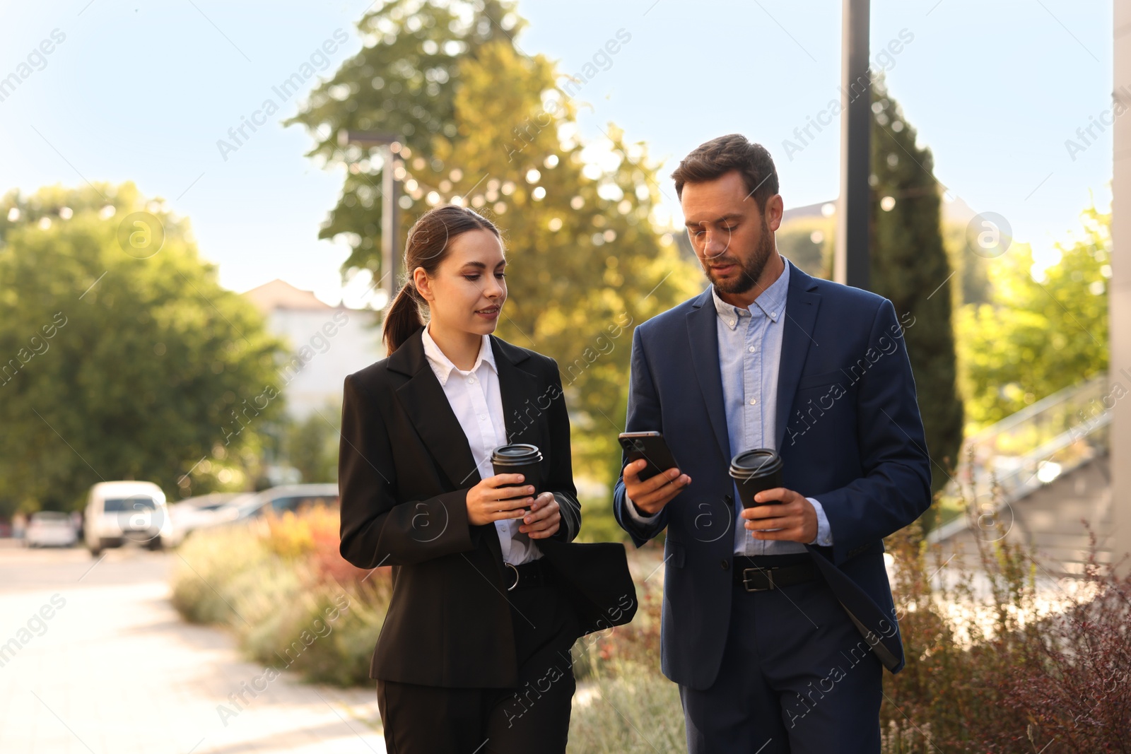 Photo of Coffee to go. Businesspeople with paper cups of drinks outdoors