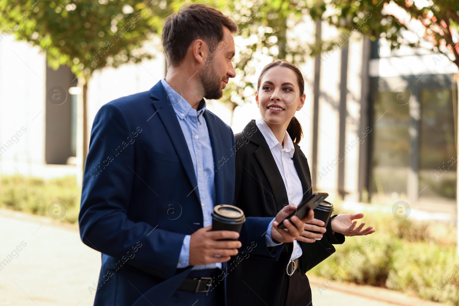 Photo of Coffee to go. Businesspeople with paper cups of drinks outdoors