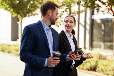 Photo of Coffee to go. Businesspeople with paper cups of drinks outdoors
