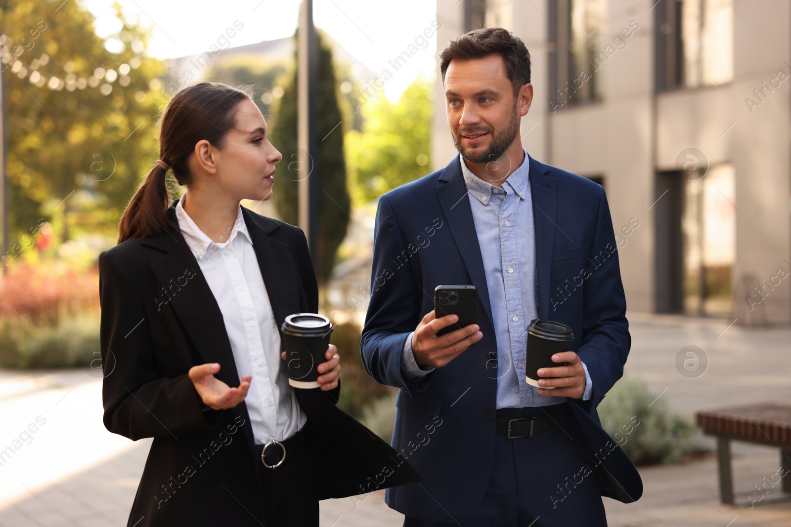 Photo of Coffee to go. Businesspeople with paper cups of drinks outdoors
