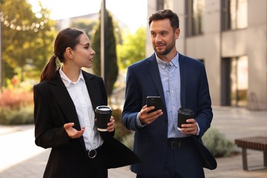 Photo of Coffee to go. Businesspeople with paper cups of drinks outdoors