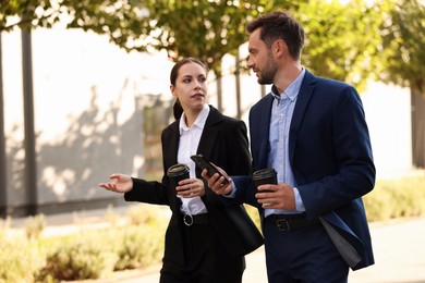 Photo of Coffee to go. Businesspeople with paper cups of drinks outdoors