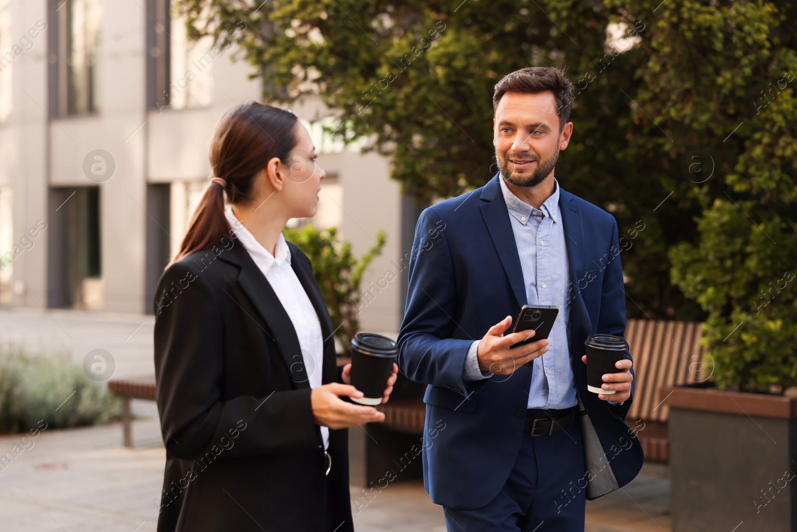Photo of Coffee to go. Businesspeople with paper cups of drinks outdoors