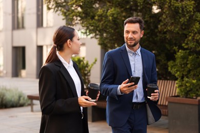 Photo of Coffee to go. Businesspeople with paper cups of drinks outdoors