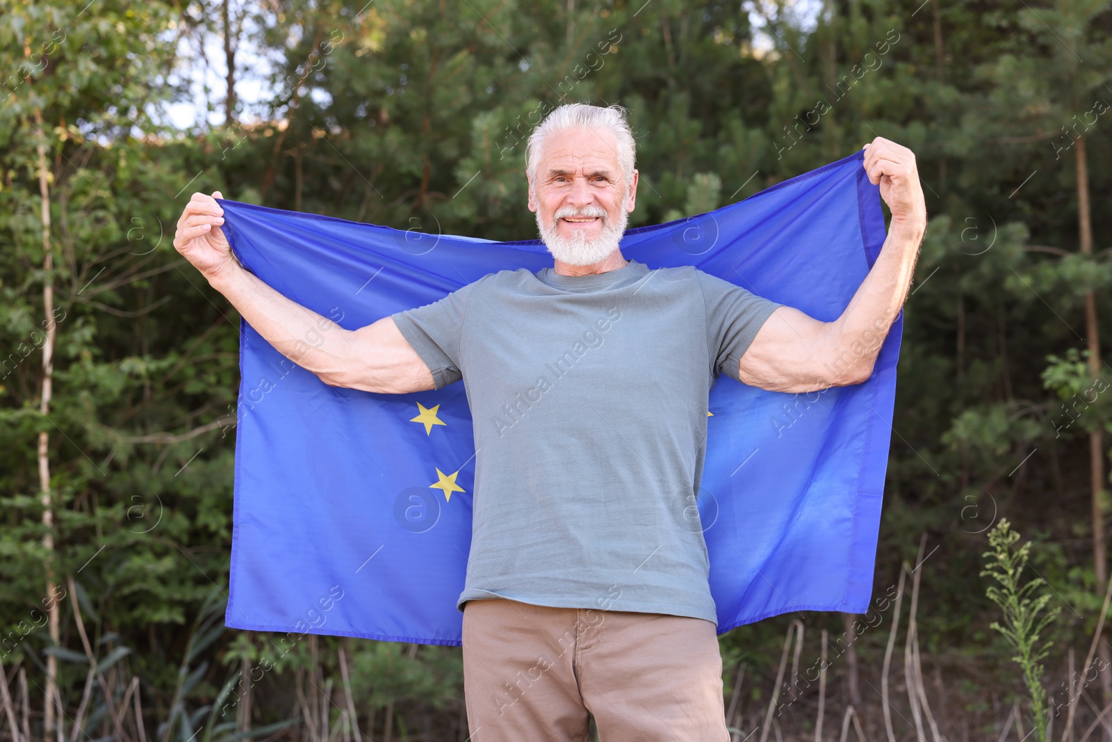 Photo of Smiling elderly man with flag of European Union outdoors
