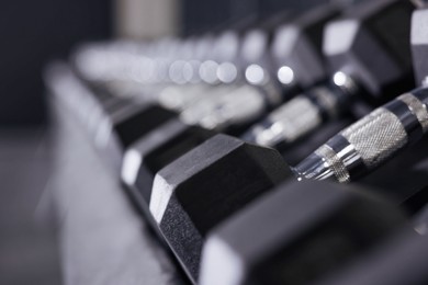 Photo of Different dumbbells in gym, closeup. Sport equipment