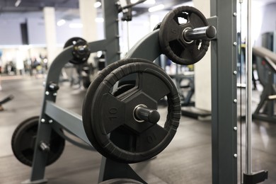 Photo of Stand with barbell discs in gym. Sport equipment