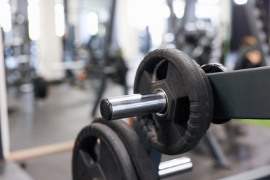 Photo of Stand with barbell discs in gym, closeup. Space for text