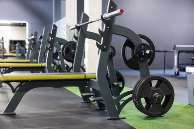Photo of Weight benches with barbell and discs in gym