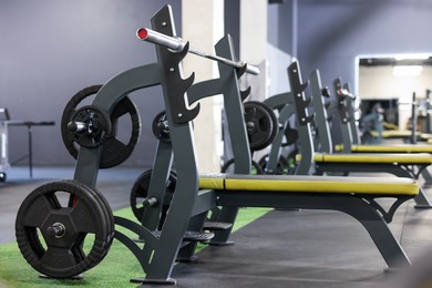 Photo of Weight benches with barbell and discs in gym