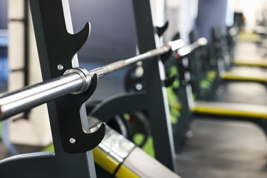 Photo of Weight bench with barbell in gym, closeup