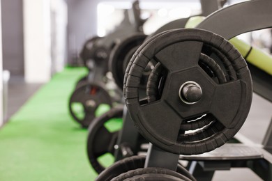 Photo of Stand with barbell discs in gym, closeup. Space for text
