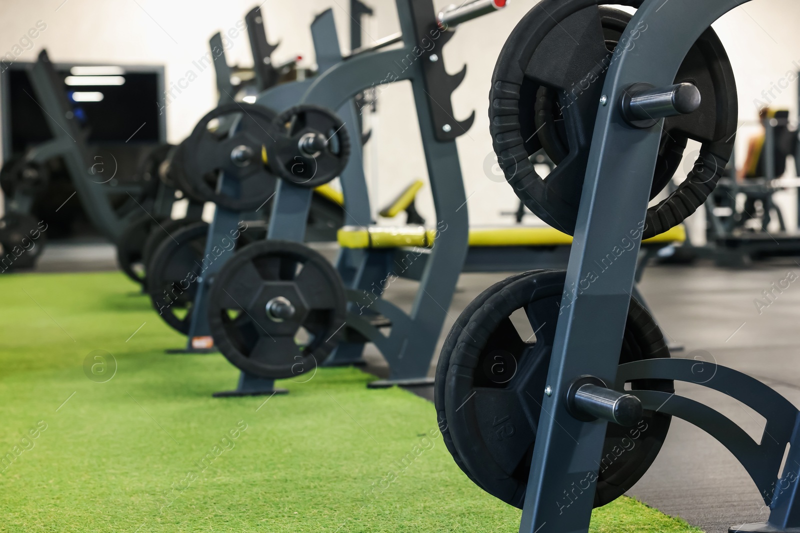 Photo of Stands with barbell discs in gym. Sport equipment
