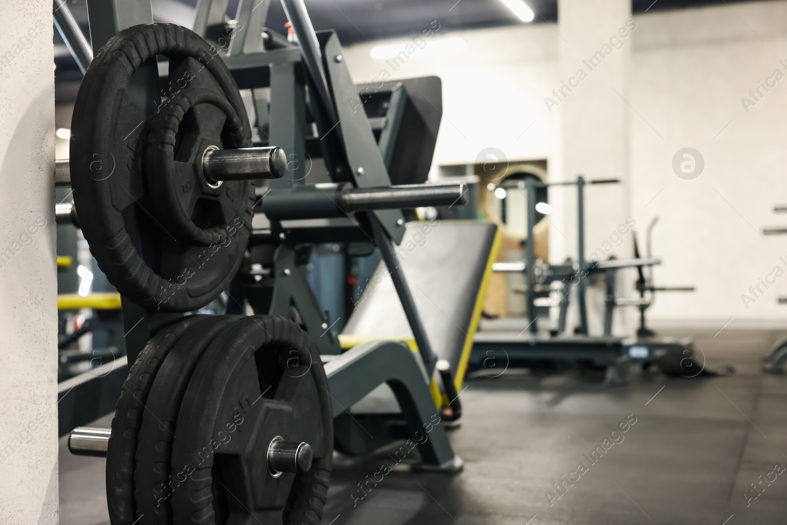 Photo of Many barbell discs and other sport equipment in gym. Space for text