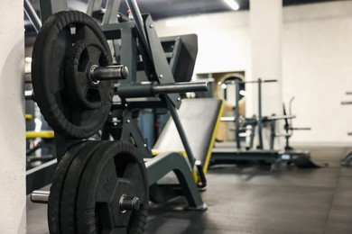 Photo of Many barbell discs and other sport equipment in gym. Space for text