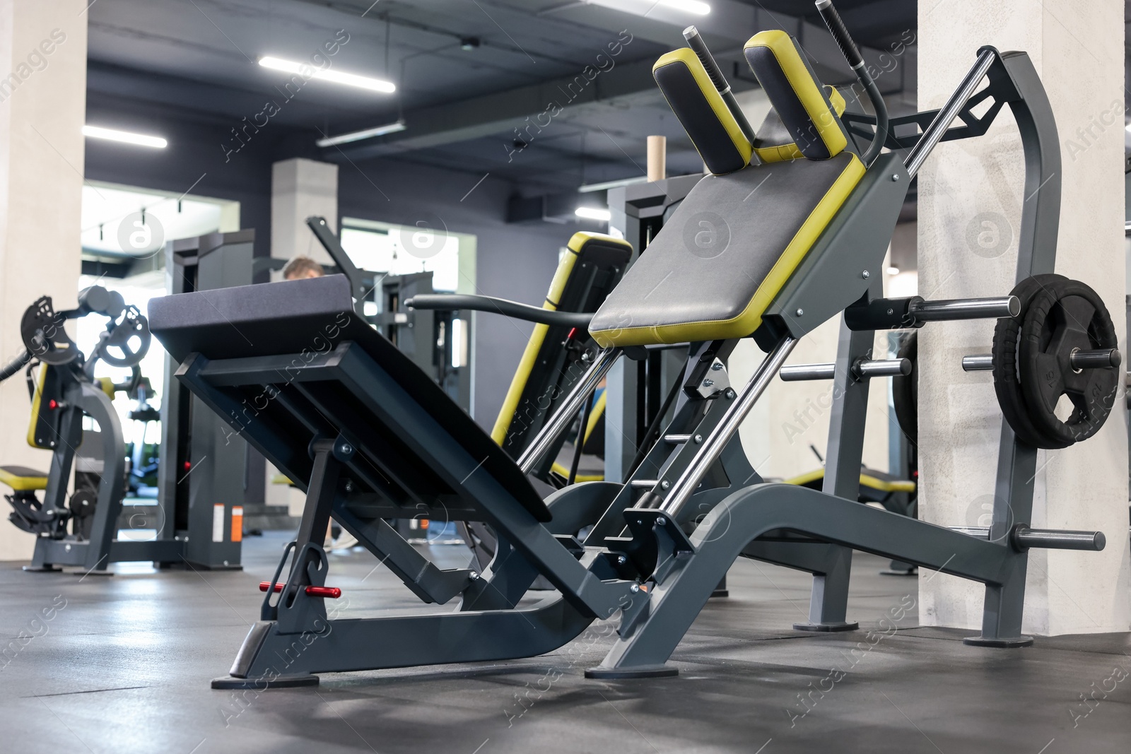 Photo of Leg press machine on floor in gym. Sport equipment