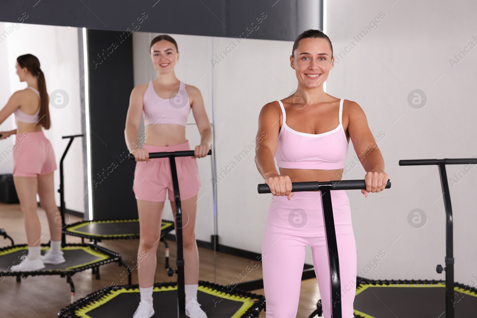 Smiling women on mini exercise trampolines in fitness studio Photo of Smiling women on mini exercise trampolines in fitness studio