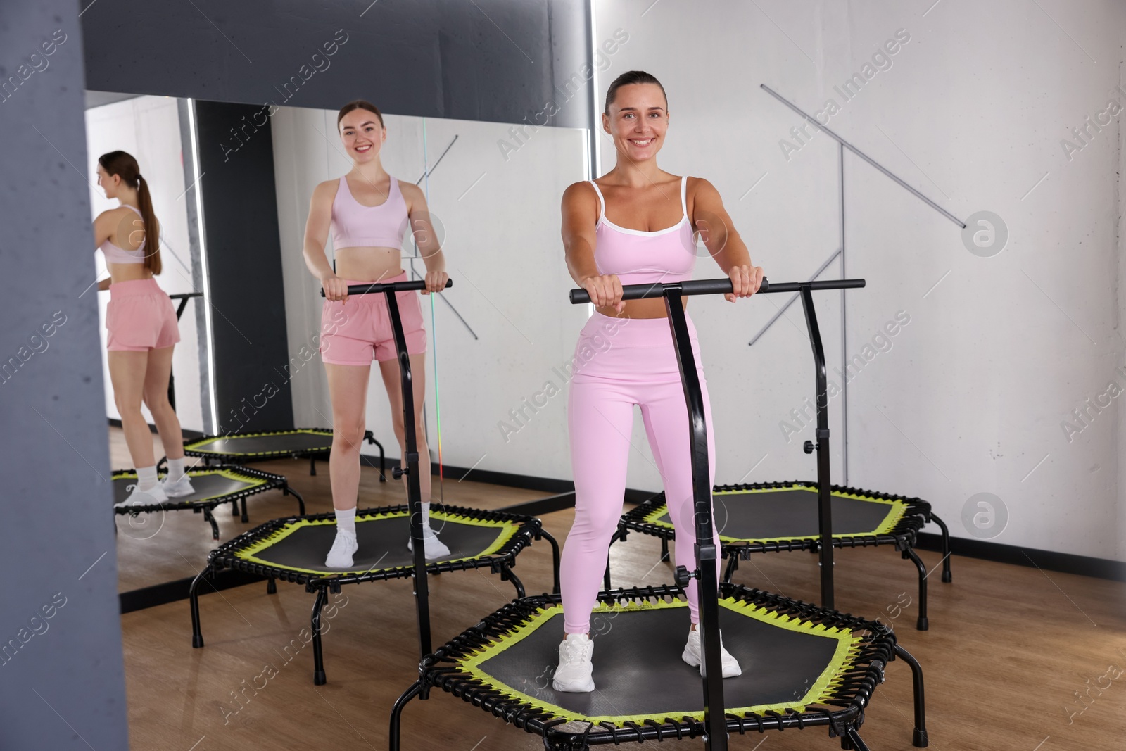 Smiling women on mini exercise trampolines in fitness studio Photo of Smiling women on mini exercise trampolines in fitness studio