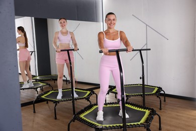 Photo of Smiling women on mini exercise trampolines in fitness studio