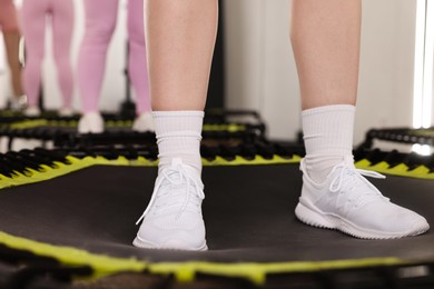 Photo of Women training on mini exercise trampolines in fitness studio, closeup