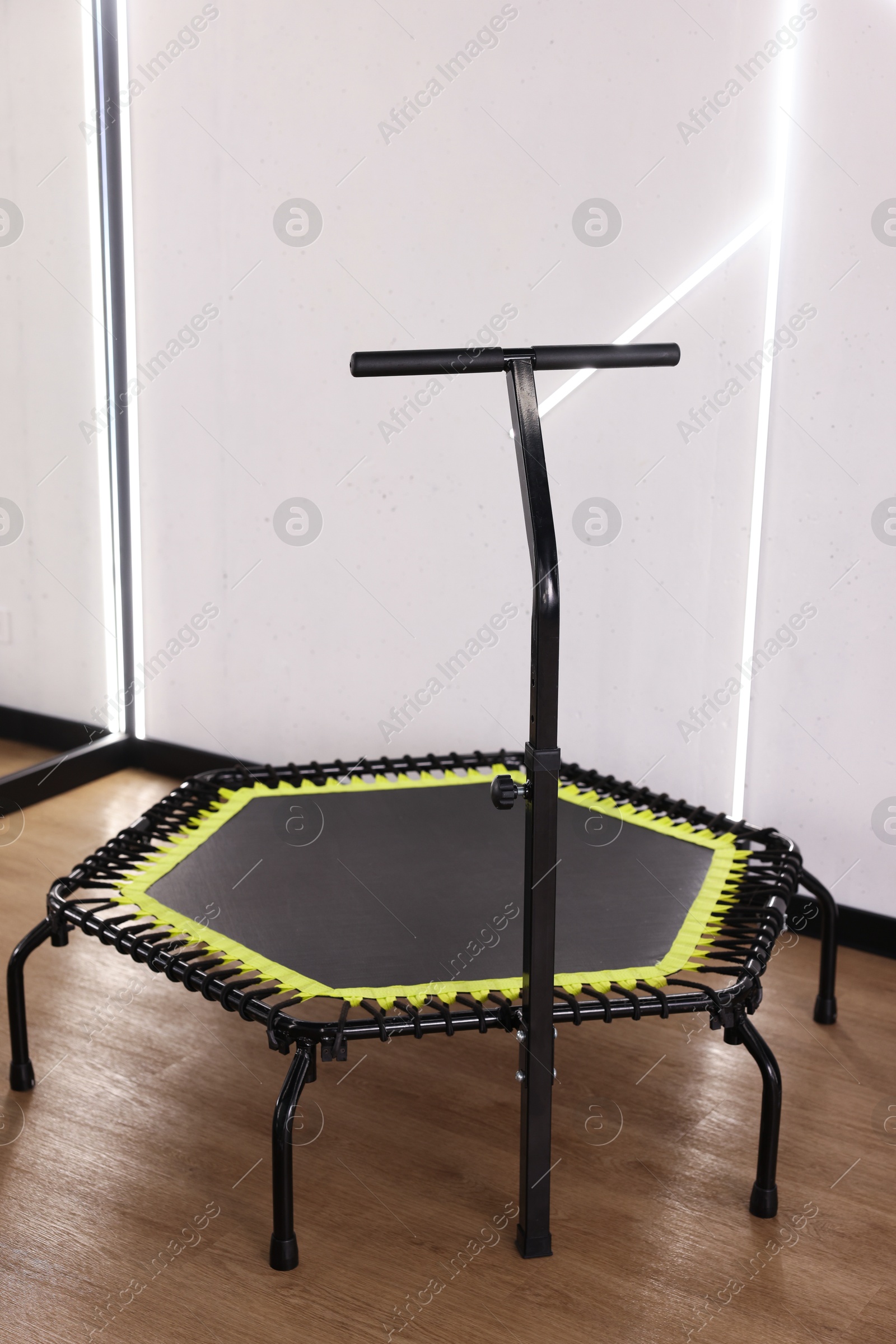 Mini exercise trampoline near white wall in fitness studio Photo of Mini exercise trampoline near white wall in fitness studio