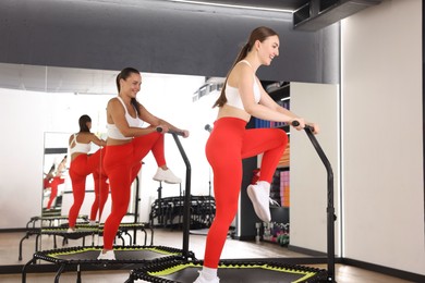 Photo of Smiling women training on mini exercise trampolines in fitness studio