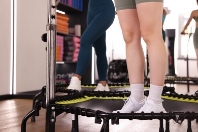 Photo of Women training on mini exercise trampolines in fitness studio, closeup