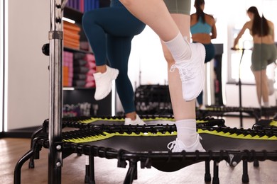 Photo of Women training on mini exercise trampolines in fitness studio, closeup