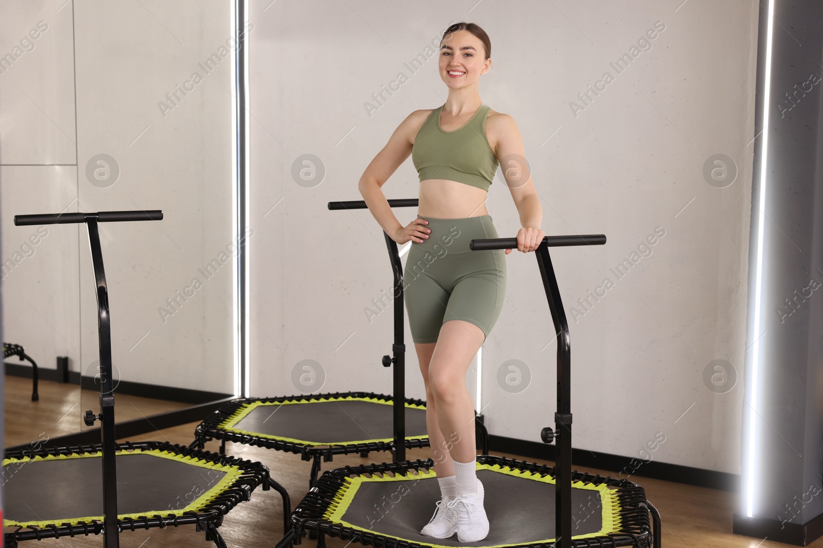 Smiling woman on mini exercise trampoline in fitness studio Photo of Smiling woman on mini exercise trampoline in fitness studio