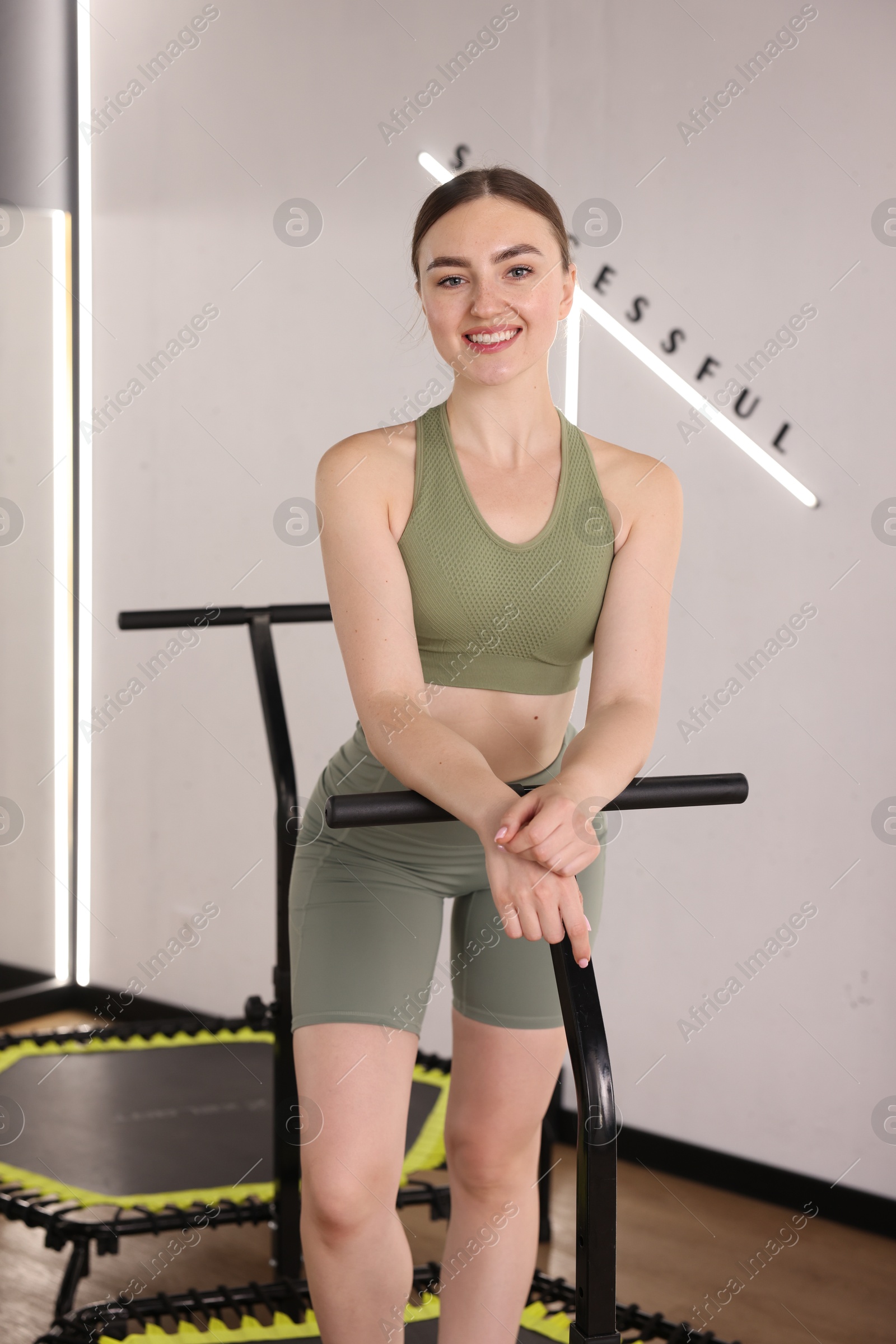 Smiling woman on mini exercise trampoline in fitness studio Photo of Smiling woman on mini exercise trampoline in fitness studio