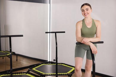 Photo of Smiling woman on mini exercise trampoline in fitness studio