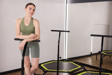 Photo of Smiling woman on mini exercise trampoline in fitness studio