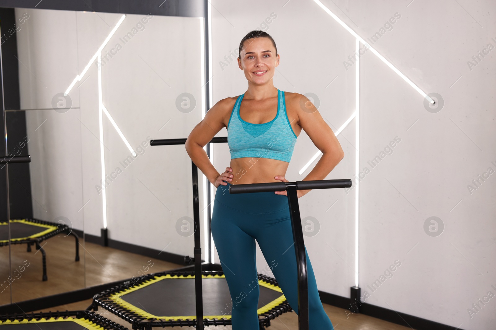 Smiling woman on mini exercise trampoline in fitness studio Photo of Smiling woman on mini exercise trampoline in fitness studio