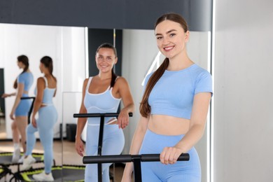 Photo of Smiling women on mini exercise trampolines in fitness studio