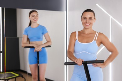 Photo of Smiling women on mini exercise trampolines in fitness studio