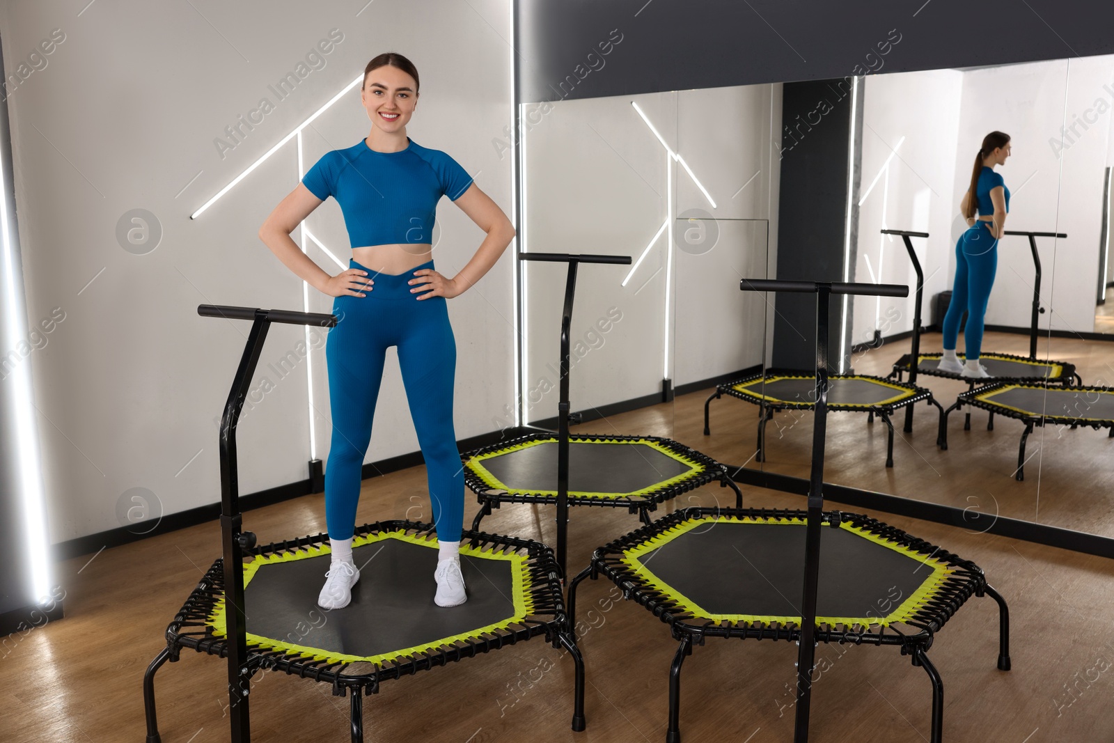 Smiling woman on mini exercise trampoline in fitness studio Photo of Smiling woman on mini exercise trampoline in fitness studio