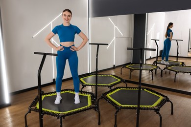 Photo of Smiling woman on mini exercise trampoline in fitness studio