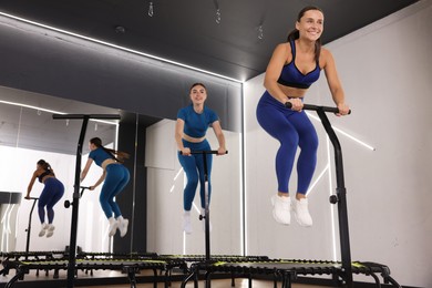 Photo of Young women jumping on mini exercise trampolines in fitness studio, low angle view