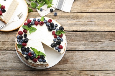 Photo of Tasty crepe cake with berries on wooden table, flat lay. Space for text