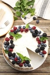Photo of Tasty crepe cake with berries on wooden table, flat lay