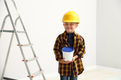Photo of Choice of profession. Little boy with bucket of paint pretending to be painter indoors