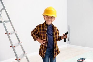 Photo of Choice of profession. Little boy with spatula tool pretending to be builder indoors