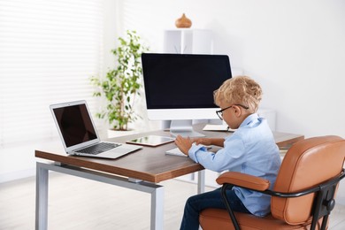 Photo of Choice of profession. Little boy pretending to work in office