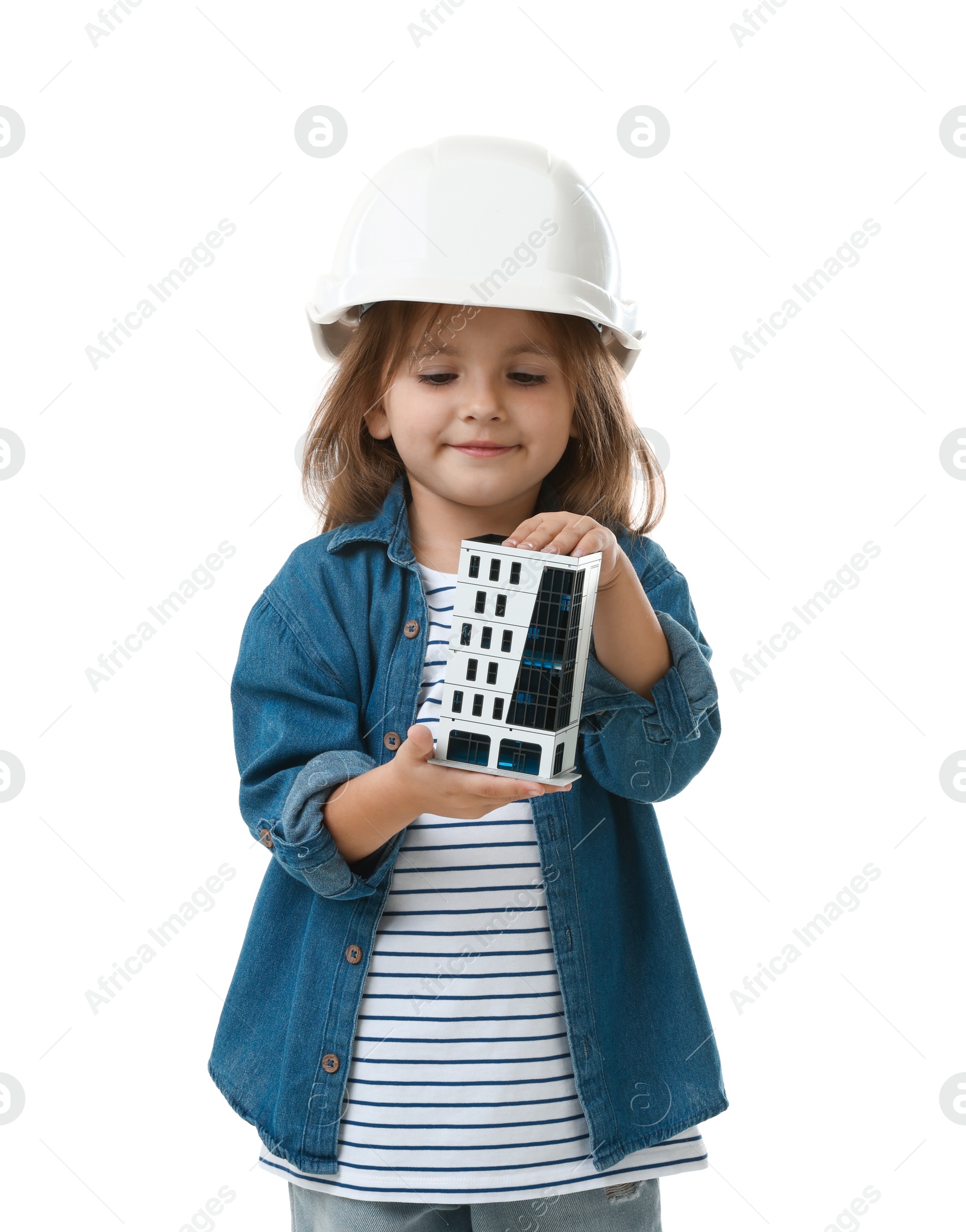 Photo of Choice of profession. Little girl in hardhat with building model pretending to be architect on white background