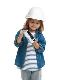 Photo of Choice of profession. Little girl in hardhat with building model pretending to be architect on white background