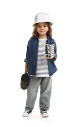 Photo of Choice of profession. Little girl in hardhat with building model and drawing tube pretending to be architect on white background