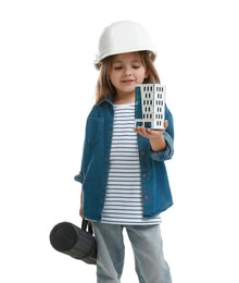 Photo of Choice of profession. Little girl in hardhat with building model and drawing tube pretending to be architect on white background